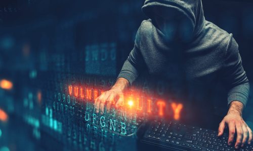 Hacker with his hands on two keypads and digital computer code