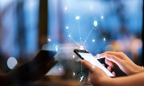 Handsome young businessman working on a laptop and drinking a coffee during an expectation of a flight.